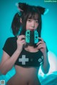 A woman in a black shirt holding a Nintendo Switch controller.