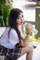 A young woman sitting on a bench holding a bottle of water.