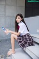 A woman sitting on the steps holding a bottle of water.