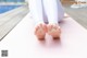 A woman is sitting on a yoga mat with her feet up.