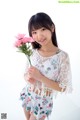 A young woman holding a bunch of pink flowers.