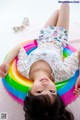 A little girl laying on an inflatable rainbow ring.