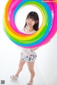 A young girl holding a large inflatable ring in her hands.