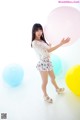 A woman standing in front of a bunch of balloons.