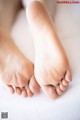 A close up of a person's feet on a bed.