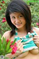 A young woman in a green and white dress posing for the camera.