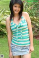 A young woman in a green and white striped top and denim skirt.