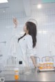 A woman in a lab coat holding a test tube.