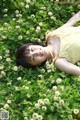 A woman laying in a field of white flowers.