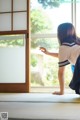 A woman in a school uniform standing in front of a window.