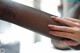 A close up of a woman's hand holding a piece of fabric.