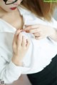 A woman wearing a white shirt and black skirt.