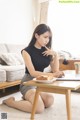 A woman sitting on the floor with a laptop and a cup of coffee.