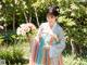 A woman in a colorful dress holding a bouquet of flowers.