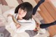 A woman in a school uniform laying on a bed.