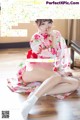 a woman in a kimono sitting on the floor