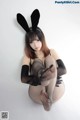 A woman in a bunny costume is posing for a picture.