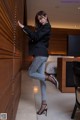 A woman leaning against a wall in a hotel room.