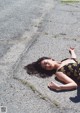 A woman laying on the ground in a black and gold dress.