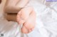 A close up of a person's bare feet on a bed.