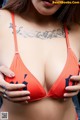 A woman in a bikini with a tattoo on her chest.