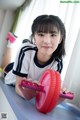 A young girl laying on the floor holding a pink wheel.